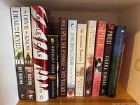 Top shelf with first 11 books including Kit Rocha, Kresley Cole, Jodi Wallace, Robyn Carr, Priest, Spice, Fireworks Over Toccoa