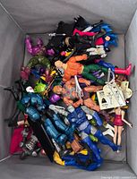 Overview of bin filled with mixed action figures