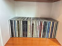 Row of 30 jewel-case music CDs on shelf