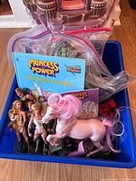 Blue bin with figures, horse, mini comics, accessory bags