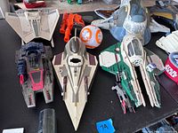 Multiple Star Wars spacecraft and accessories laid out on table