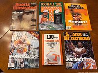 Six Tennessee Volunteers Sports Illustrated magazines and one book displayed on table