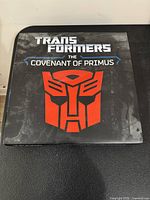 Front of outer slipcase displaying title and red Autobot emblem