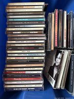 Stack of approximately 37 female pop artist CDs in jewel cases; visible album titles and spines