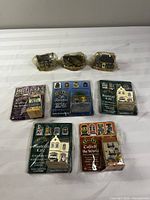 Group shot showing three plastic-wrapped houses and five blister-packed houses