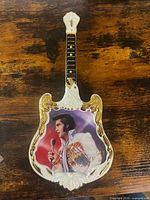 Front view of guitar-shaped Elvis Presley plate showing image, gold trim, colors, overall condition