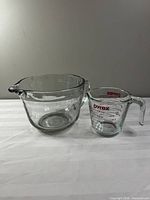 Front view of both measuring cups showing size difference and spouts
