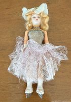 Front view of Madame Alexander doll showing outfit, hair, facial features and ice skates