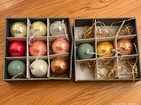 Two open boxes showing 18 multicolor glass Christmas ball ornaments with dividers and packing material