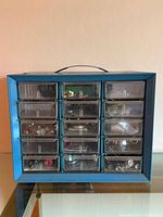 Front view of blue Akro-Mils cabinet showing 15 clear drawers with contents