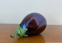 Side view showing full eggplant form with green stem