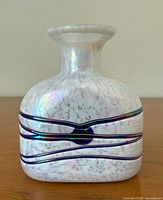 Front view of iridescent art glass vase showing ribbon bands and mottled finish