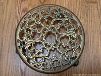 Top view of ornate brass pot stand showing full scroll pattern