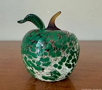 Front view of clear crystal apple with green frit pattern, leaf and stem visible