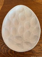 Top view of the ceramic deviled egg platter showing twelve recessed wells and overall condition