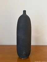 Full frontal view of tall charcoal ceramic vase