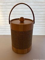 Front view of cylindrical wood ice bucket showing cane wrap