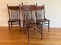 four oak carved spindle dining chairs grouped