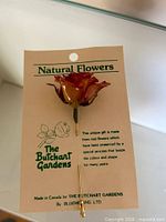 Full view of rose stick pin on branded card