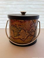 Front view showing world map design, lid, handle