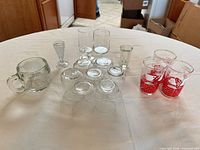 All seventeen glass items arranged on table