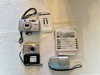 All three cameras with manuals and accessories displayed