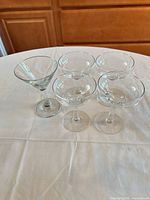 Four clear stemmed glasses: one martini, three coupe