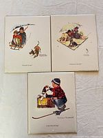 Three mounted Norman Rockwell prints on white background