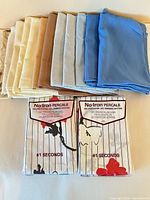 Stack of folded pillowcases in assorted solid colors with two packaged pillowcases