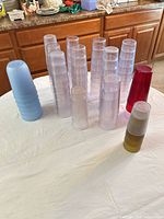 Stacks of clear, blue, red and smoke/olive translucent plastic tumblers on table