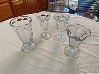 Set of four clear glass parfait/sundae glasses on table