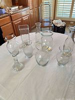 Group shot of all eight clear glass vases on table