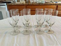 All eight clear stemmed goblets arranged on table