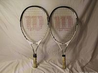Front view of both Wilson US Open Jr. racquets showing frames, strings, and grips