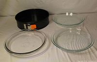 Overall lot with Le Creuset springform pan and three glass pie plates laid flat