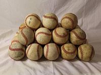 Pyramid stack of used baseballs showing wear and quantity representation