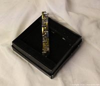 Bracelet shown in presentation box highlighting two-tone Greek key links