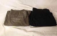 Both pairs of pants folded side by side