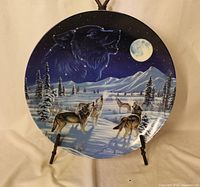 Front view of wolf-themed porcelain collector plate on stand