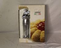 Front of retail box showing Marcato Biscuits cookie press inside window