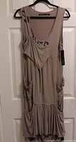 Front view of Animale Sport taupe dress on hanger showing design details and hangtag