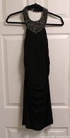 Front view of black beaded-collar halter dress on hanger