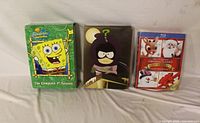 Front view of three boxed video sets: SpongeBob SquarePants Season 1, South Park Season 13, Original Christmas Classics Anniversary Edition