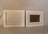 Both white photo frames side by side showing front view, mats visible, confirms quantity and condition