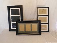 Front view of three black multi-photo frames showing mats and overall design