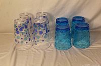 Eight plastic glasses grouped by style on plain background