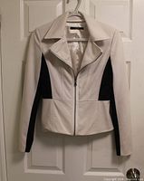 Front view of cream and black Tahari jacket hanging on door