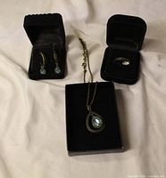 Ring, necklace and earrings set displayed in boxes