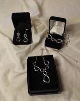 Necklace, bracelet and earrings set in black boxes