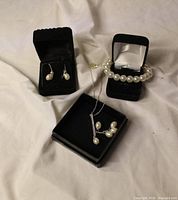 Full view of necklace, bracelet, and earrings in boxes